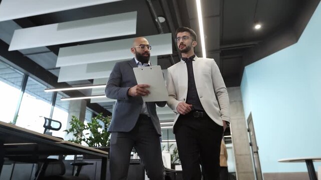 Two professionals walk through a modern office space