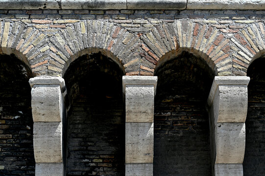 old light color brick and stone arches in closeup view. front elevation. textured stone columns, ledges and sill. arts and architecture concept. medieval  architecture.   