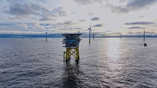 Marine substation surrounded by wind turbines in offshore wind farm
