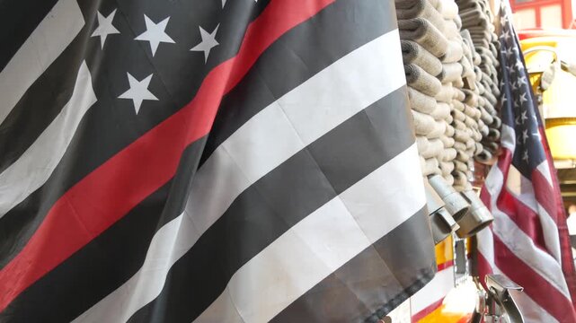 Red thin line black american flag on firefighter truck. Hose of firetruck and fire fighters symbol in New York, United States. 911 remembrance, fire department engine vehicle. September 11 Patriot Day