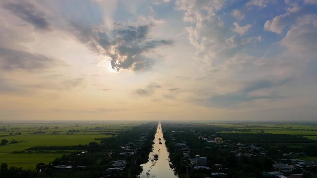 Drone tilting up to majestic sunbeams through clouds at countryside sunrise