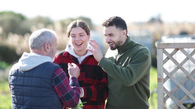 Farmers friendly talking outside next to wooden fence on background with farm. High quality 4k footage