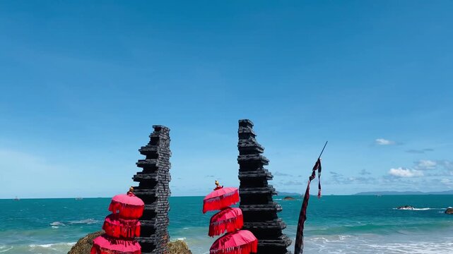 Balinese split gate and red umbrellas on tropical beach. 4K Video