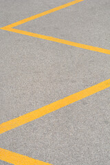 Fototapeta premium Thick yellow thermoplastic paint applied as a zigzag traffic line on a coarse asphalt road surface
