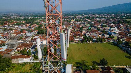 Aerial View of Cellular Telecommunications Tower Near Football Field in Urban Area © katakaneh