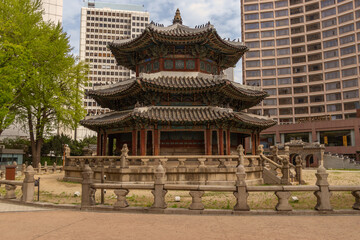 Obraz premium Traditional Korean pagoda architecture contrasted with modern skyscrapers in downtown Seoul