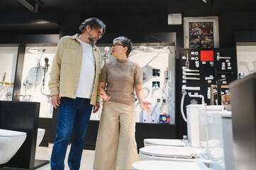 Naklejka premium Senior couple discussing bathroom renovation in showroom