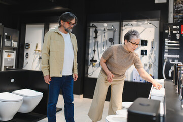 Fototapeta premium Senior couple choosing bathroom fixtures for home renovation