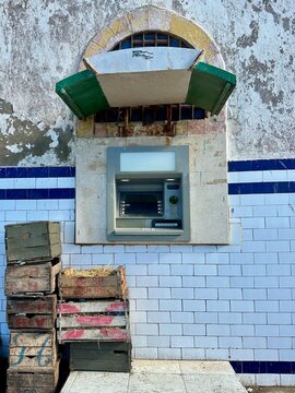 ATM Cash Machine Embedded in Ornate Arch on Tiled Wall with Wooden Crates, Morocco