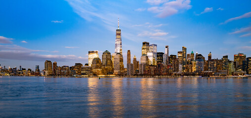 Fototapeta premium New York skyline with Freedom Tower. New York Lower Manhattan at twilight. New York illuminated buildings by river. New York scenic cityscape.