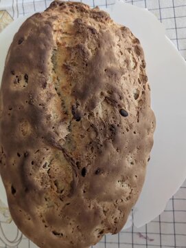 Pane fatto in casa con crosta rustica e dorata, caratterizzato da una superficie irregolare e artigianale, ideale per contenuti dedicati alla cucina casalinga, alla panificazione