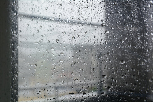 台風の日の窓ガラスに付いた水滴と雨模様