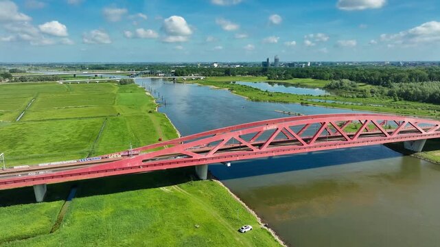 Aerial footage of the Hanzeboog (Hanseatic Arch), a combined railway and cycle bridge spanning the IJssel river. The bridge was opened in June 2011