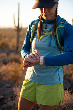 Woman checks her smartwatch while on a run in the Arizona desert..