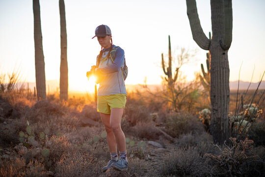 Woman checks her smartwatch while on a run in the Arizona desert.