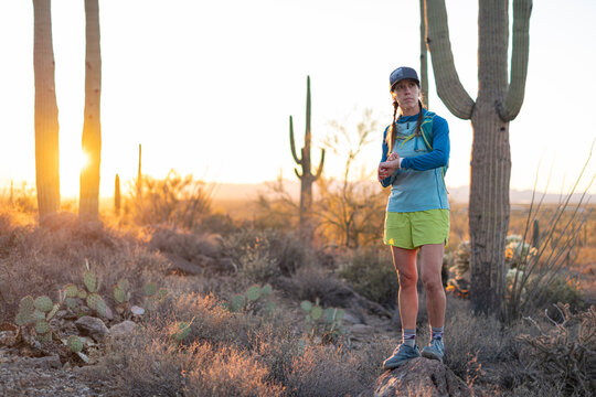 Woman checks her smartwatch while on a run in the Arizona desert.