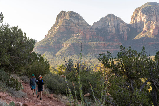 Two friends hiking on a desert mountain trail