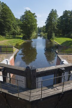 A wooden river lock leads into a forest that lines the water, Tartak Lock, Augustow Canal, Augustowski Canal, Suwałki, Podlaskie, Podlaskie, Poland