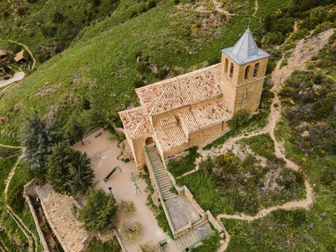 Close-up of a small stone church on a green hill surrounded by paths and trees, aerial view, Las Pe&ntilde;as de Riglos, As Penyas de Riglos, Huesca, Aragon, Spain