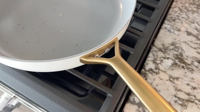 Ceramic frying pan heating on stove top
