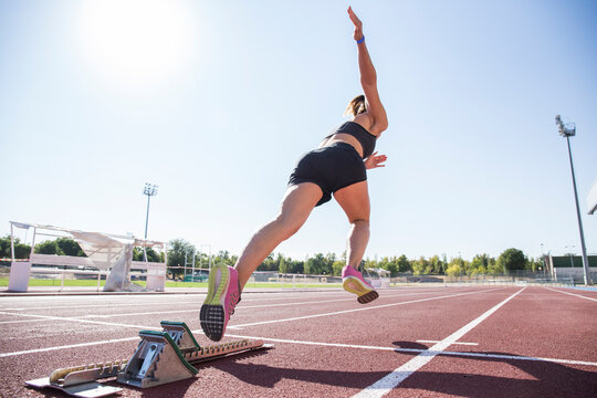 Female runner on tartan track starting