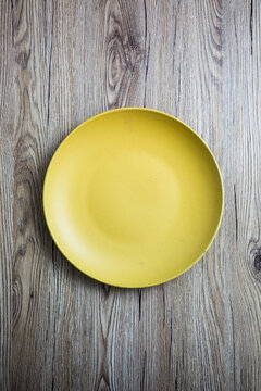 Empty yellow plate on wood