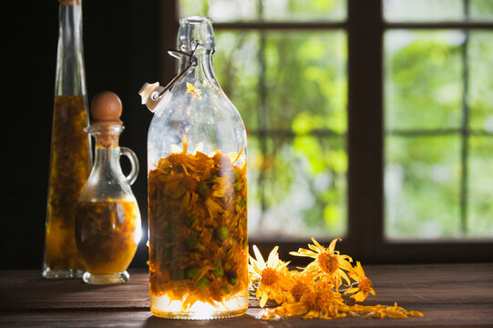 Austria, Salzburger Land, Arnica flower preserved in bottle on table