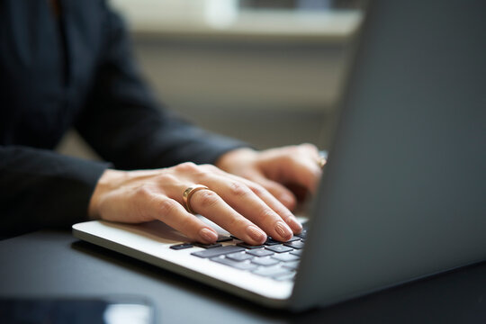 Businesswoman's hands typing on laptop in office