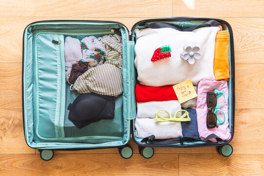 Suitcase packed with clothes in hotel room