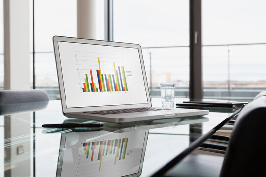 Laptop with bar chart on office desk