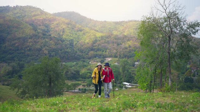 Caucasian hikers with backpacks walking together on a trail in mountains. 