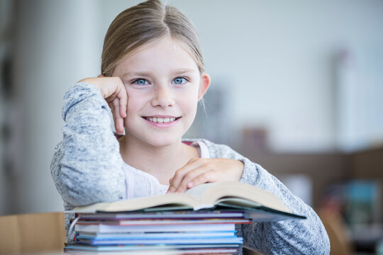 A cheerful schoolgirl poses with her books, radiating positivity and eagerness to learn.