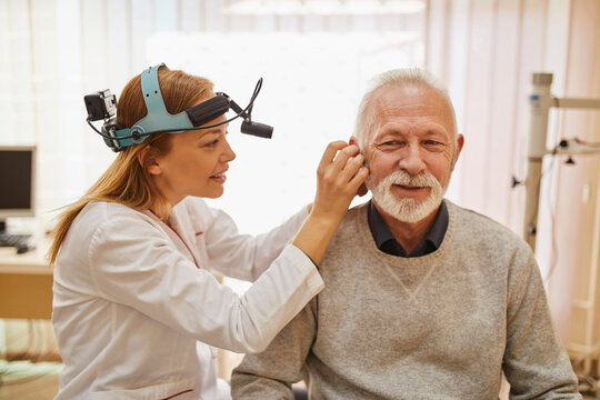 ENT physician examining ear of a senior man