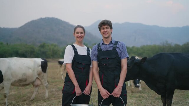 Portrait of Caucasian man and woman dairy farmers working at livestock farm. 