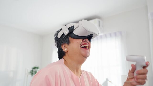 Asian senior elderly woman using technology VR glasses and playing game. 