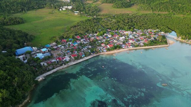 Scenic aerial flyover of Magnesia Del Norte in Virac, Catanduanes, showing a rural coastal barangay, shoreline, and lush tropical island scenery