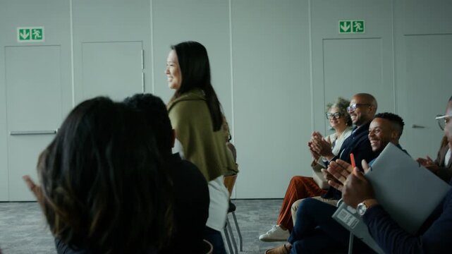 Diverse professionals applaud a speaker during a business conference meeting. An appreciative audience shows support and enthusiasm, celebrating achievement and collaboration in a dynamic environment.
