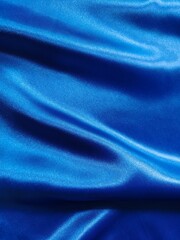 Fototapeta premium Luxurious royal blue satin fabric shimmers with elegant folds, creating a rich and sophisticated abstract texture.