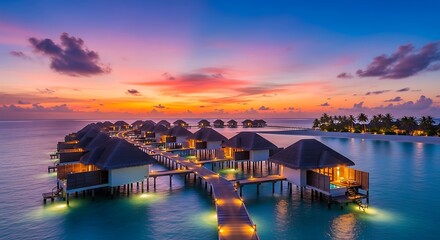 Fototapeta premium Luxurious Overwater Bungalows Glowing at Tropical Island Resort During Colorful Sunset