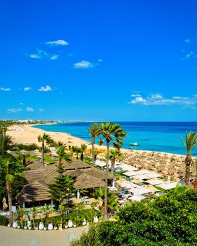 Hammamet, Tunisia - MAY 16, 2025: Beach of Hammamet, the first tourist destination in Tunisia. Located on the Gulf of Hammamet. Beach and boats on shallow water, view on Mediterranean sea. Crystal-cle