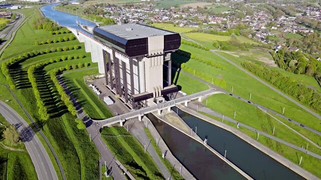 Aerial drone view of canal lift basin with monolithic concrete architecture and natural elements surrounding waterway. Large-scale infrastructure with reservoir and green landscape from altitude.