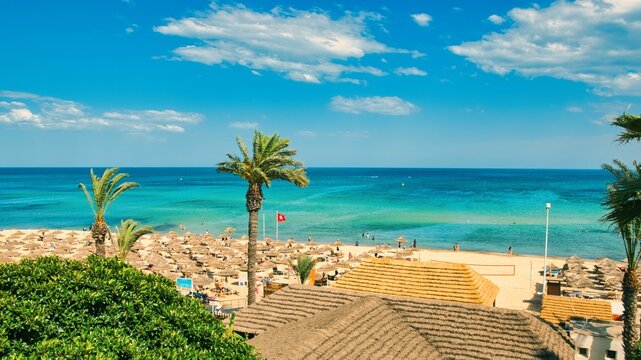 Hammamet, Tunisia - MAY 16, 2025: Beach of Hammamet, the first tourist destination in Tunisia. Located on the Gulf of Hammamet. Beach and boats on shallow water, view on Mediterranean sea. Crystal-cle
