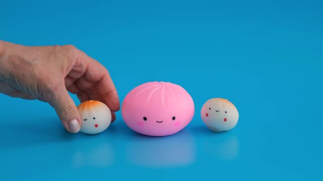 Three soft anti-stress toys in the shape of a dumpling with a happy face on a blue background