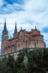 Obraz premium Covadonga in Asturias is a historic mountain village known for its sacred cave, basilica, and stunning natural surroundings.