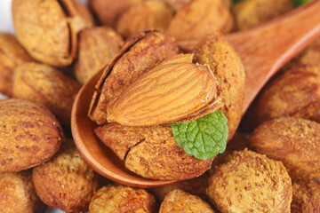 Raw Almonds in Wooden Spoon with Mint Leaf - Natural Healthy Nuts for Baking and Snacking © NgoVan