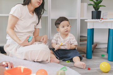 Fototapeta premium Young parents hugging and playing with baby at home, showing love, care, and emotional bonding, capturing warm family moments, affection, and happiness in early childhood lifestyle.