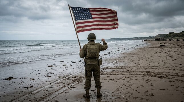 A reenactor dressed as a World War II United States Army soldier stands on a sandy beach holding an American flag against a moody, overcast sky, evoking historical themes of D-Day and liberation.
