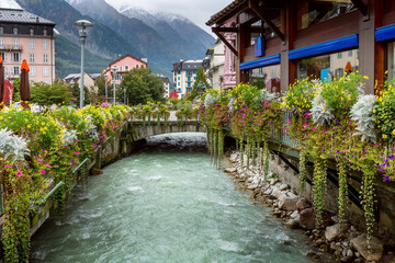 Fototapeta premium River and houses, flowers in center of Chamonix, France.