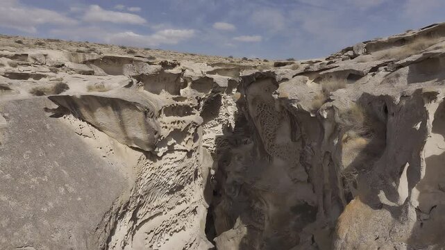 Drone flying through arid eroded rock formations, Mangystau, Kazakhstan