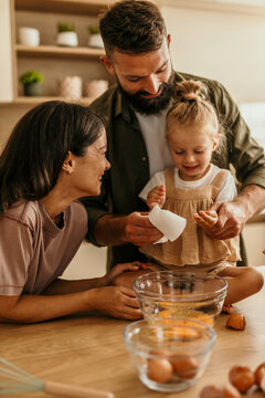 Family baking together in kitchen learning cooking skills